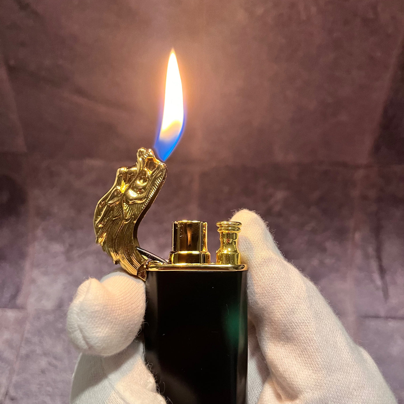 Black & Gold Dragon Lighter – refillable butane lighter with dragon head design producing a tall orange-blue soft flame, held in a gloved hand