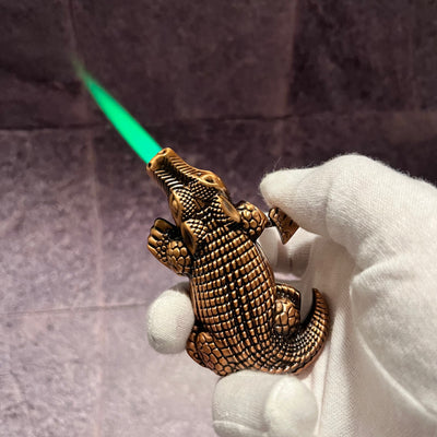Crocodile Torch Lighter – bronze refillable butane torch lighter shaped like a crocodile, ignited with a vivid green flame during use.
